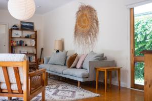 a living room with a couch and a table at Bessie at Merricks Beach in Coles Beach