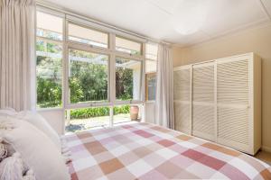 a bedroom with a bed and a large window at Bessie at Merricks Beach in Coles Beach