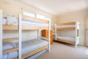 a room with two bunk beds and a window at Bessie at Merricks Beach in Coles Beach