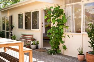 a front porch of a small house with plants at Bessie at Merricks Beach in Coles Beach