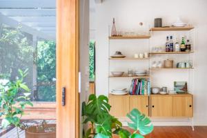 a room with a book shelf with dishes on it at Bessie at Merricks Beach in Coles Beach