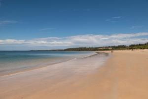 a beach with people walking on the sand and the water at Bessie at Merricks Beach in Coles Beach