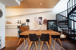a dining room with a wooden table and chairs at Loft Living Close to the MCG in Melbourne