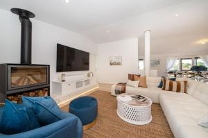a living room with a white couch and a fireplace at Dundas on the Beach at St Andrews in Saint Andrews Beach