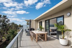 einen Balkon mit einem Tisch und Stühlen auf einem Haus in der Unterkunft Beachfront Apartment with lots of Wow in Rosebud