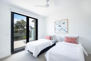 Duas camas num quarto com uma janela em Beachfront Apartment with lots of Wow em Rosebud