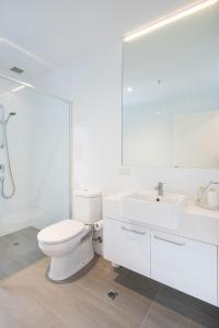 uma casa de banho branca com um WC e um lavatório em Beachfront Apartment with lots of Wow em Rosebud
