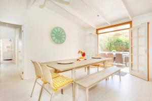 a dining room with a table and chairs and a clock at Dromanas Beachside Hideaway in Dromana