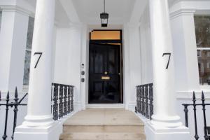 una puerta negra en la parte delantera de una casa blanca en Gulaid House Knightsbridge by Bob W London, en Londres