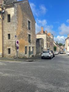 une rue avec des voitures garées sur le côté d'un bâtiment dans l'établissement Tour St Sauveur, à Bellême