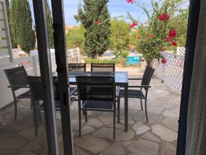 un tavolo in vetro e sedie su un patio di Spacious 3 bed, 2 bath maisonette in Regina Gardens a Paphos