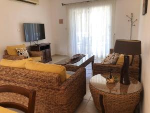 Spacious 3 bed, 2 bath maisonette in Regina Gardens في Paphos: غرفة معيشة بها كنبتين وتلفزيون