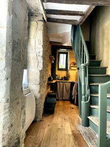- un couloir avec un mur en pierre et des escaliers dans l'établissement Tour St Sauveur, à Bellême