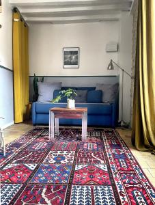 - un salon avec un canapé bleu et une table dans l'établissement Tour St Sauveur, à Bellême