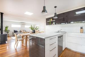 cocina con armarios blancos y comedor en Elizabeth Lodge with Spa Walk to beach, en Capel Sound 20 fotos más