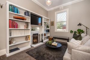 a living room with a couch and a tv at Sandy Village Retreat Heated Pool Bay Views in Sandringham