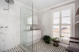 a white bathroom with a shower and a sink at Sandy Village Retreat Heated Pool Bay Views in Sandringham