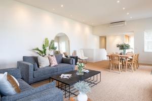 a living room with a couch and a table at Grand Victoria Beach House in Melbourne