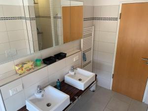 a bathroom with two sinks and a mirror at Panorama Apartment in Kandern