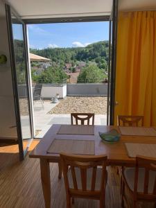 a dining room with a table and chairs and a patio at Panorama Apartment in Kandern