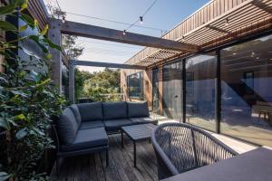 a patio with a couch and chairs on a deck at Lexicon House with Pool in Blairgowrie in Blairgowrie
