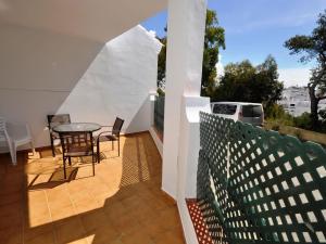 d'une terrasse avec une table et des chaises sur un balcon. dans l'établissement Apartamento junto al mar Piscina solo familias, à Conil de la Frontera