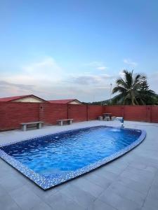 a large blue swimming pool with benches and a brick wall at TheDot 903 @ A’Famosa Villa NEW VILLA in Kampong Alor Gajah