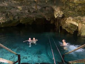 圖盧姆的住宿－Room in Lodge - Ecolush Couple Mayan Dome cenote Bikes，三人在洞穴的游泳池游泳