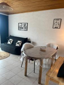 - un salon avec une table et un canapé dans l'établissement Alpes Sweet Home - Concorde Moon' Tain, à L'Alpe-d'Huez