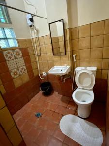 a bathroom with a toilet and a shower and a sink at Rio Vista Bed and Breakfast in Dagupan