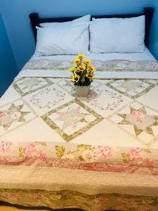 een bed met een quilt met een vaas met bloemen erop bij Vevilyn Condotel in Manilla