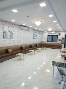 a waiting room with couches and tables and a screen at استراحة الساحل in Dumistān