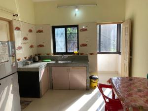 a kitchen with a sink and a refrigerator and a table at Thee Haven Candolim in Candolim