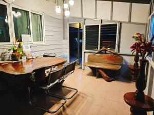 uma sala de jantar com uma mesa de madeira e um banco em P.California Inter Hostel em Nang Rong