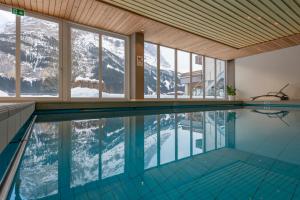 a swimming pool with a view of the mountains at Sunstar Hotel & SPA Grindelwald in Grindelwald