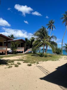 une maison sur une plage avec des palmiers et l'océan dans l'établissement Paradise Bungalows Lamai Beach, à Koh Samui 