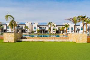 ein Resort mit einem Pool und Palmen in der Unterkunft ALEGRIA ID25 in Playa Flamenca