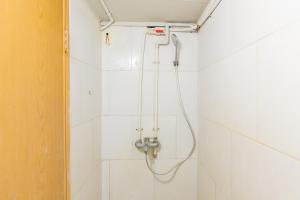 a shower in a white tiled bathroom at RedDoorz At Stariez Kemang in Jakarta