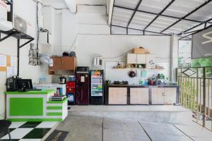 a large kitchen with a counter and a refrigerator at RedDoorz At Stariez Kemang in Jakarta