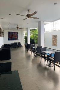 comedor con mesas y sillas y ventilador de techo en One World One Home Naiharn Hotel, en Rawai Beach