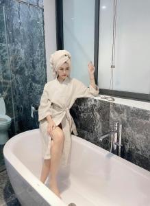 a woman is sitting in a bath tub at Sea Villa FLC Sầm Sơn - Villa SB-NT in Sầm Sơn