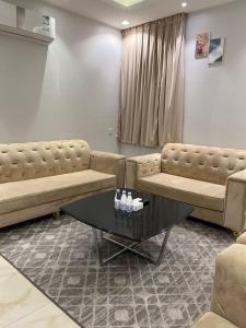 a living room with two couches and a table at العرين بارك للشقق المخدومة in Abha