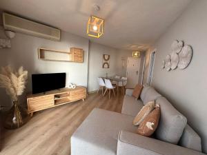 a living room with a couch and a flat screen tv at Apartamento La Concha PLAYA DE LEVANTE in Benidorm