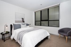 um quarto com uma cama e uma grande janela em Luxe on Main in Mornington Views of the Bay em Mornington