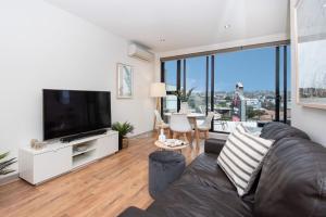 a living room with a couch and a flat screen tv at Luxe on Main in Mornington Views of the Bay in Mornington