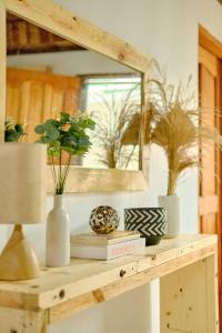 a wooden shelf with a mirror and vases on it at Pallet Homes - Ledesco in Iloilo City