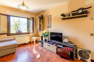 a living room with a tv and a couch at M de Puigsec Mas rural al Ripollès in Girona