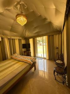 a bedroom with a bed and a chandelier at Chitragarh Farm in New Delhi