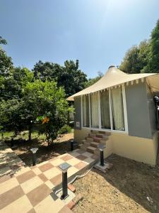 a house with a tented porch and a checkered floor at Chitragarh Farm in New Delhi