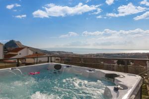 a hot tub on a balcony with a view of the ocean at Villa Helena Excelsior - With Pool, Playground, Jacuzzi and Spa in Kučine